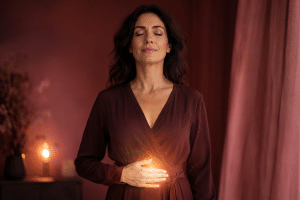 Femme sereine, main posée sur le plexus solaire, symbole de la confiance en soi retrouvée